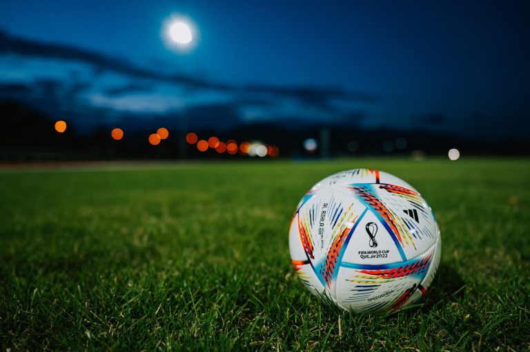A football on the pitch at night.