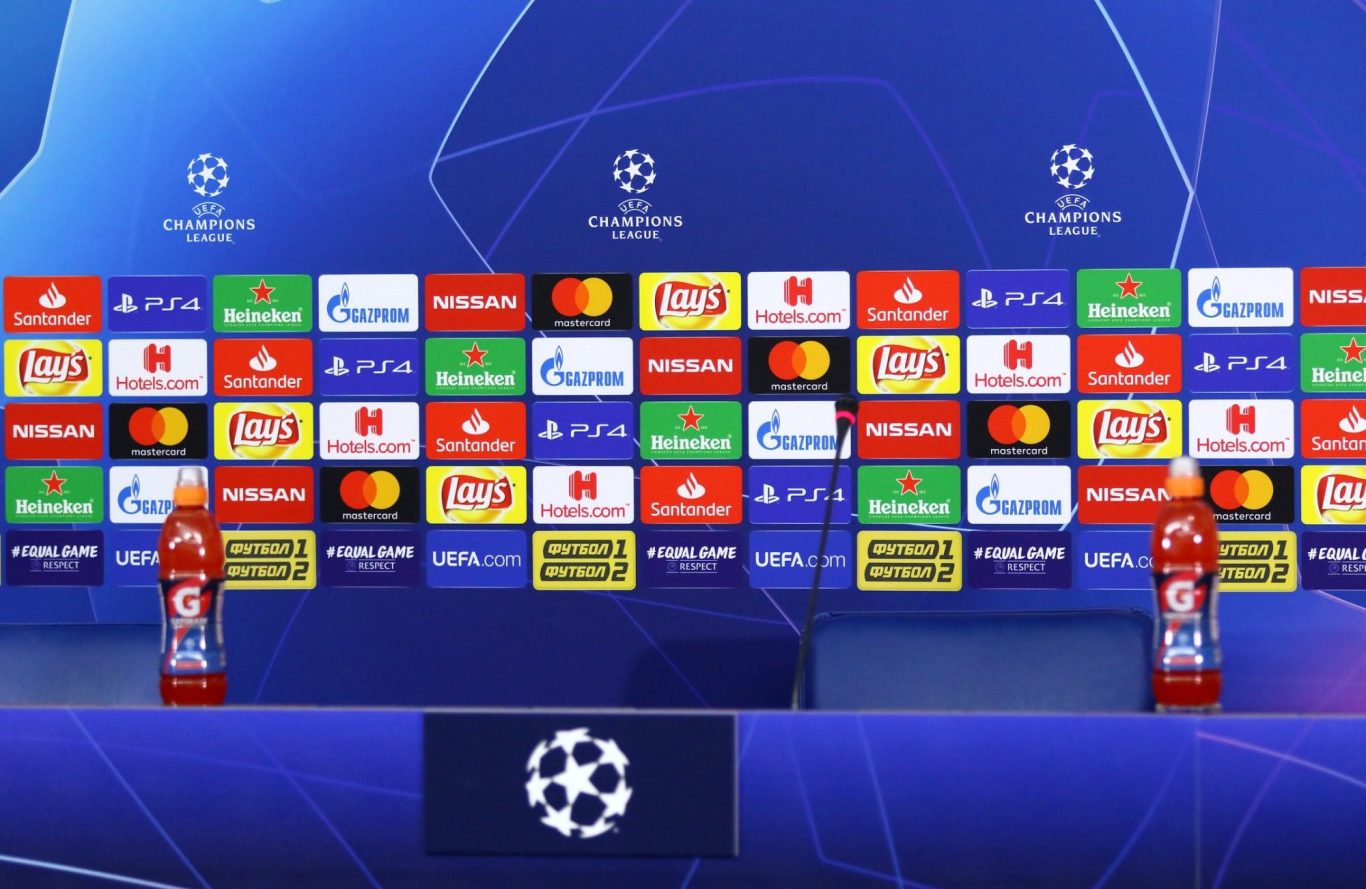 A press conference room at a UEFA Champions League match, with all the relevant branding on the back wall and around the desk.