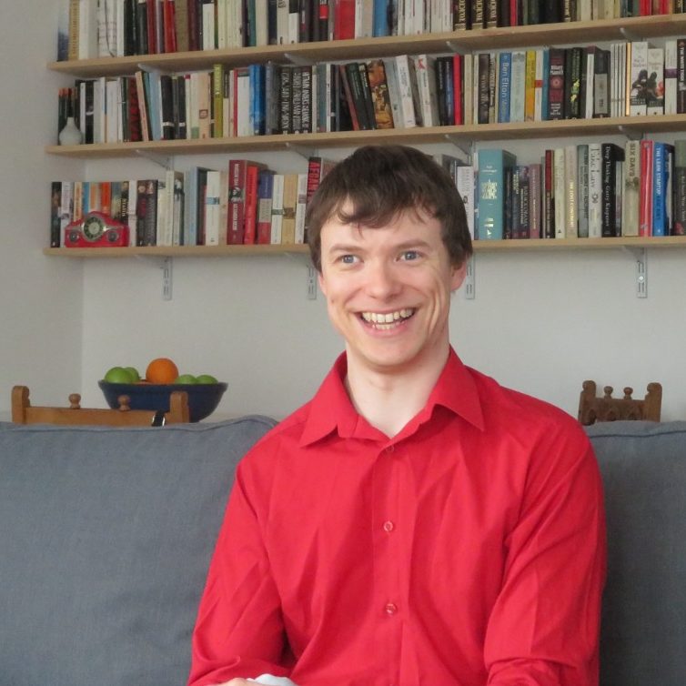 Dan on his sofa in red shirt